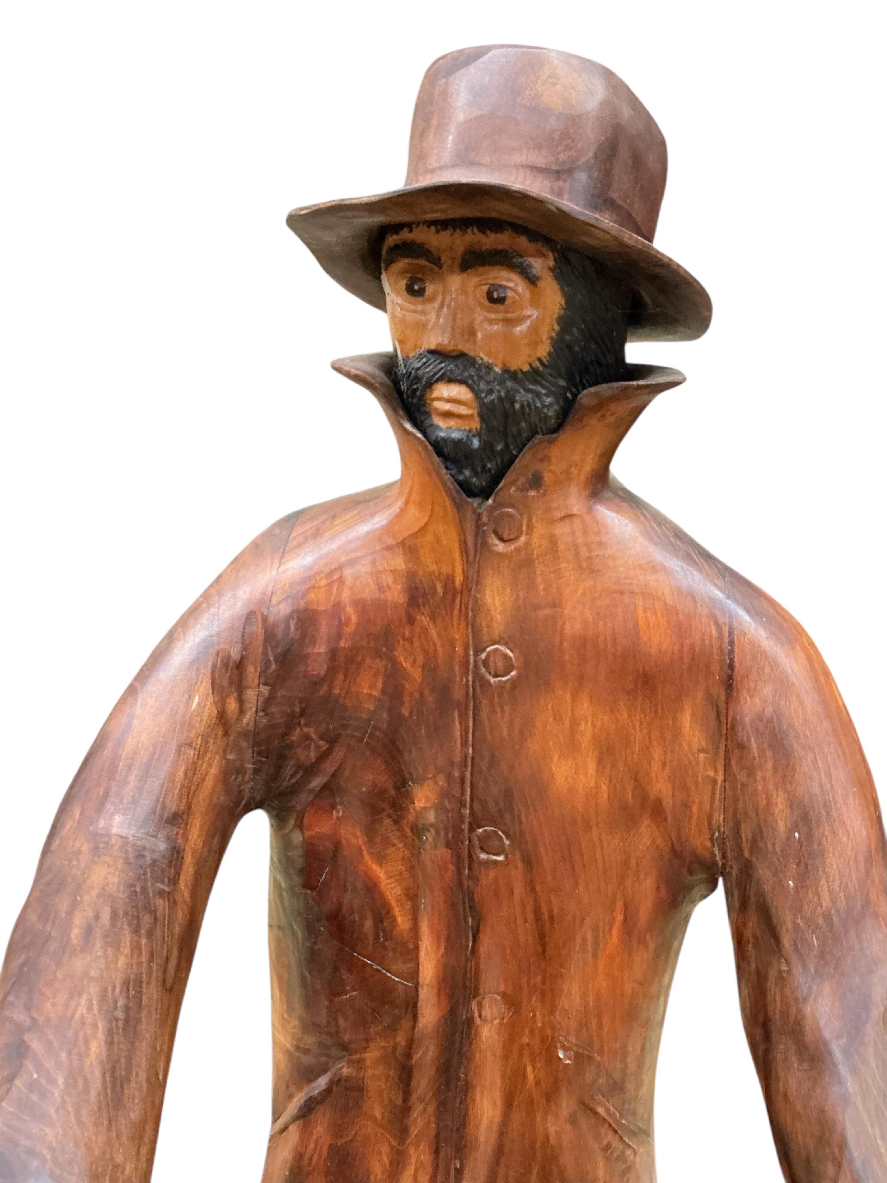 Pierre Decorse (b.1953), a carved wooden sculpture of a man playing the hurdy-gurdy